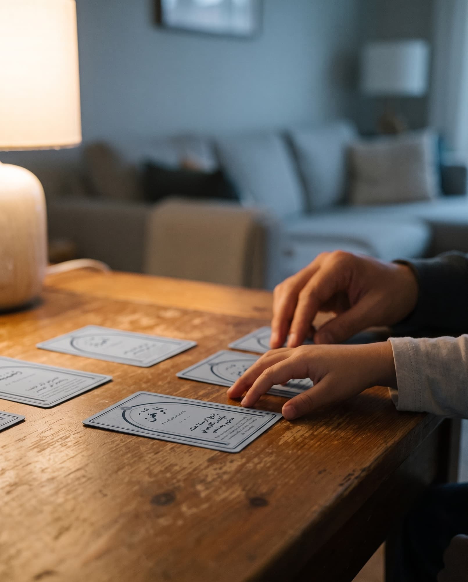 Cards on a warm wooden table, hands reaching